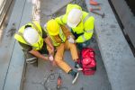 Safety team help a construction worker who has suffered a construction injury.